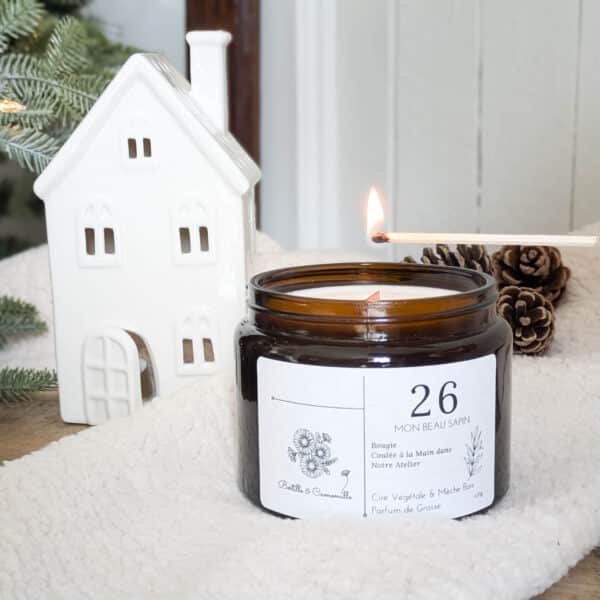 Bougie parfumée Mon beau sapin numéro 26, coulée à la main en Bourgogne avec un parfum de Grasse. Cette bougie artisanale de 470g est fabriquée à partir de cire 100% végétale. Sa mèche en bois crée une ambiance chaleureuse et apaisante.