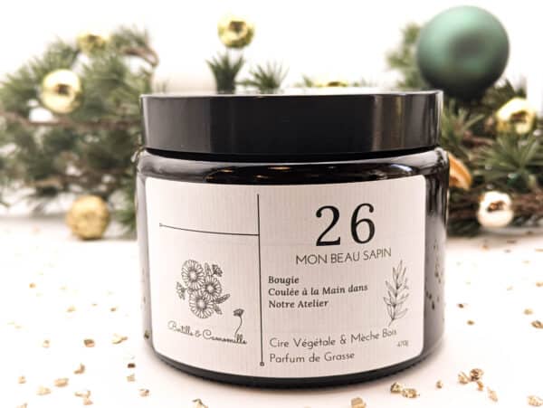 Bougie parfumée Mon beau sapin numéro 26, coulée à la main en Bourgogne avec un parfum de Grasse. Cette bougie artisanale de 470g est fabriquée à partir de cire 100% végétale. Sa mèche en bois crée une ambiance chaleureuse et apaisante.