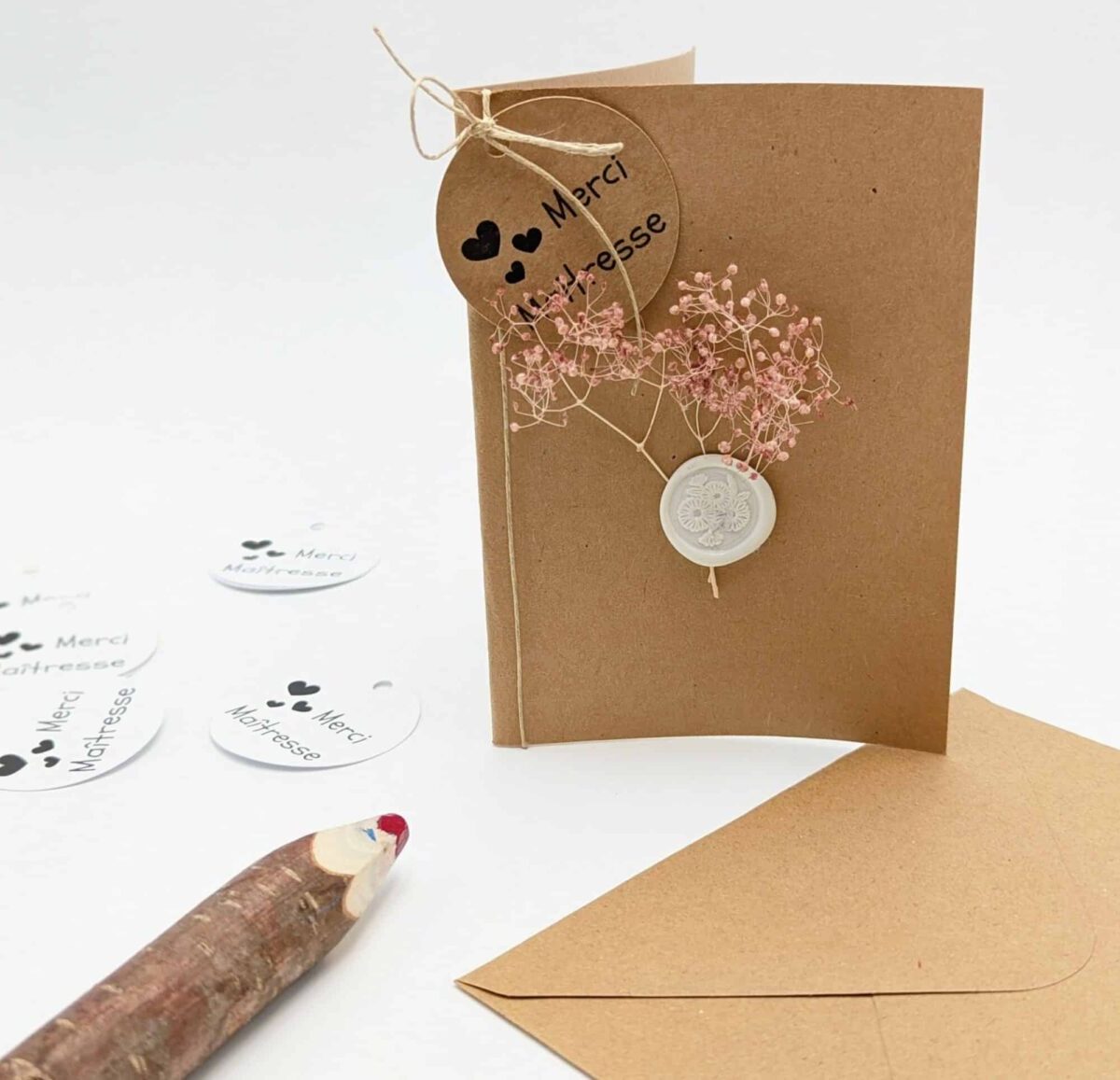 Carte cadeau fleurs séchées rose, personnalisable avec une étiquette message ronde avec texte: merci, merci maitresse, joyeux anniversaire, joyeux noël, bonne fête, elle est vendue avec une enveloppe en kraft brun.