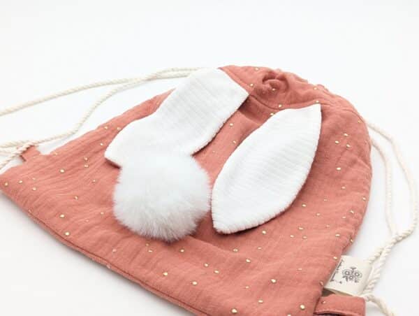Petit sac pour enfant en double gaze de coton marsala avec oreille de lapin et queue de lapin en fourrure blanche.