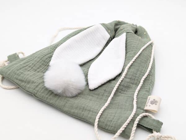 Petit sac pour enfant en double gaze de coton vert tilleul avec oreille de lapin et queue de lapin en fourrure blanche.