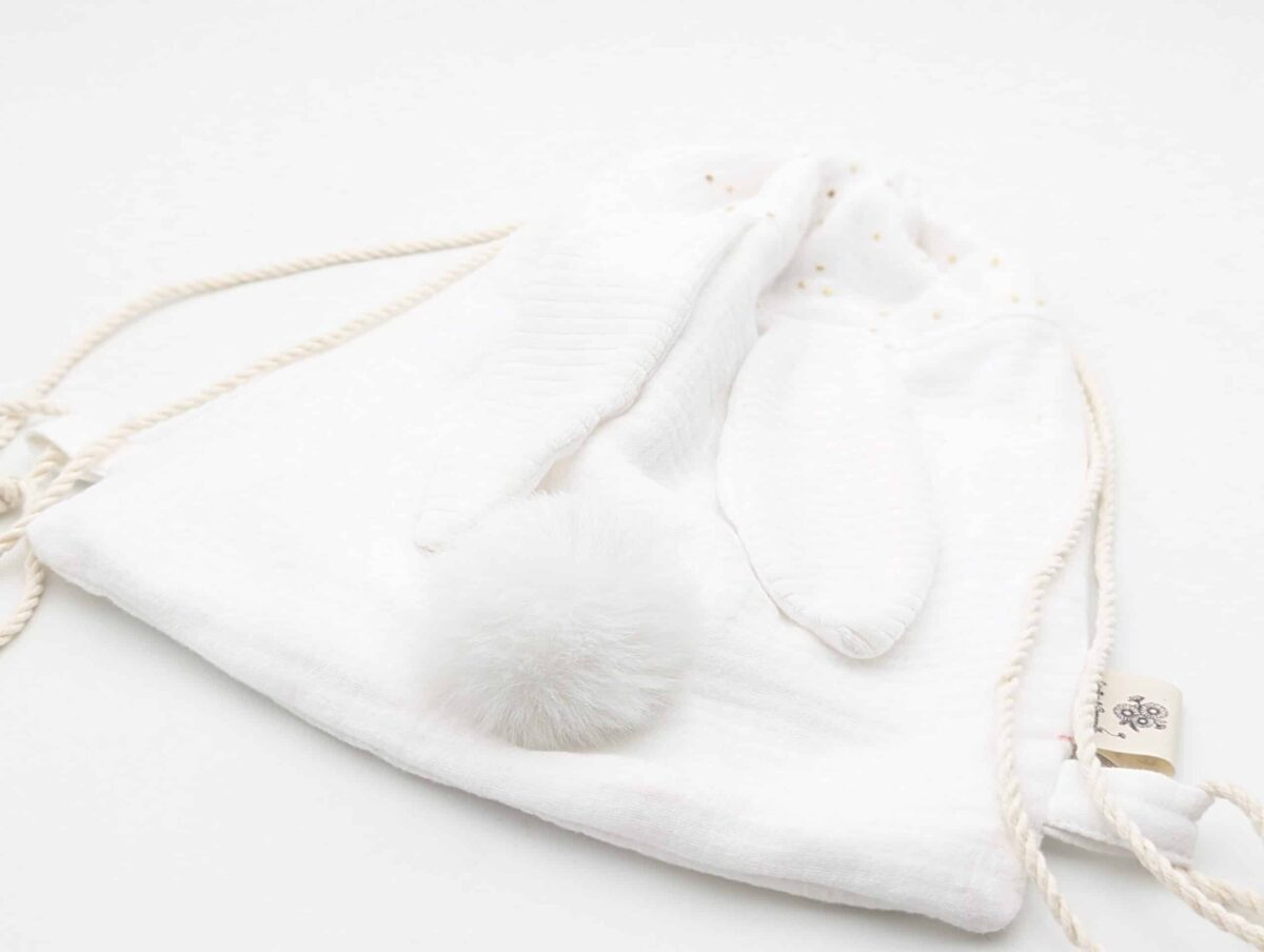 Petit sac pour enfant en double gaze de coton blanc avec oreille de lapin et queue de lapin en fourrure blanche.