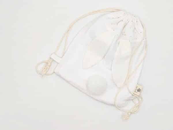 Petit sac pour enfant en double gaze de coton blanc avec oreille de lapin et queue de lapin en fourrure blanche.
