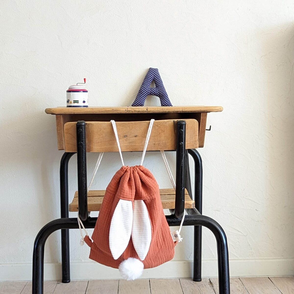 Petit sac pour enfant en double gaze de coton marsala avec oreille de lapin et queue de lapin en fourrure blanche.