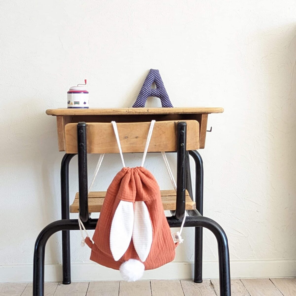 Petit sac pour enfant en double gaze de coton terracotta avec oreille de lapin et queue de lapin en fourrure blanche.