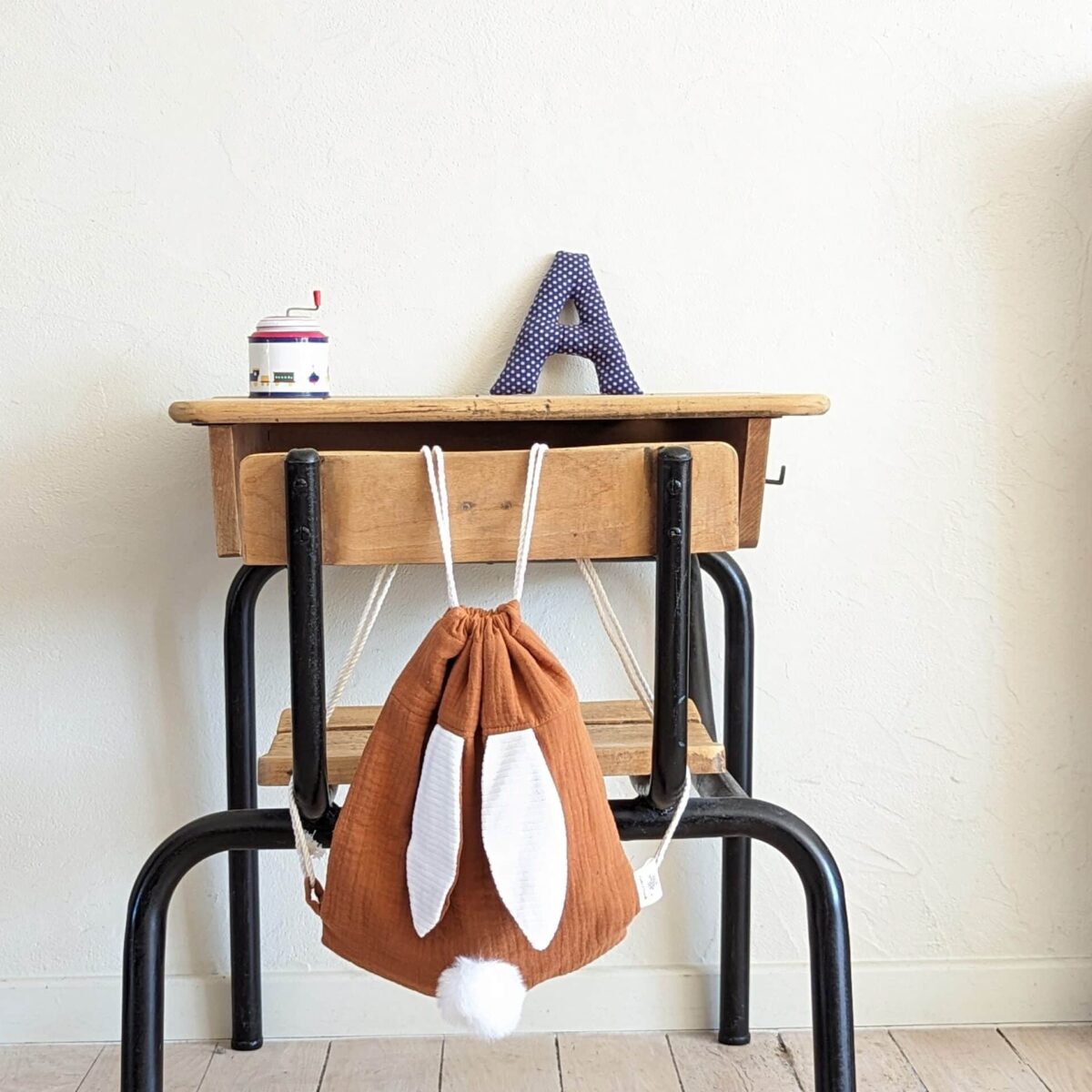 Petit sac pour enfant en double gaze de coton châtaigne avec oreille de lapin et queue de lapin en fourrure blanche.