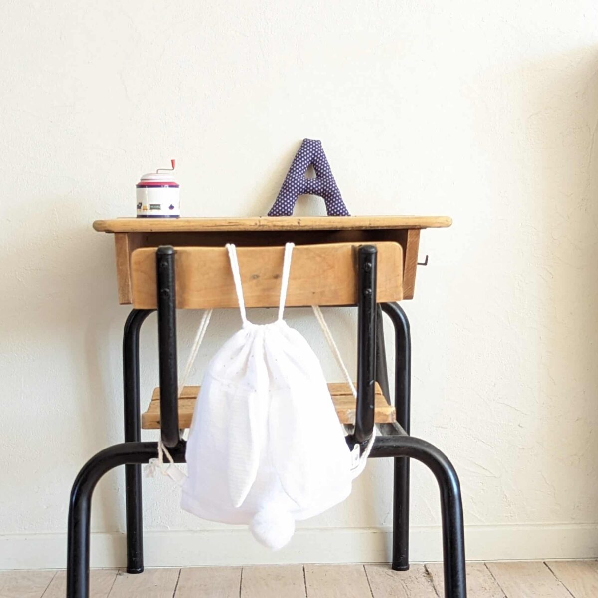 Petit sac pour enfant en double gaze de coton blanc avec oreille de lapin et queue de lapin en fourrure blanche.