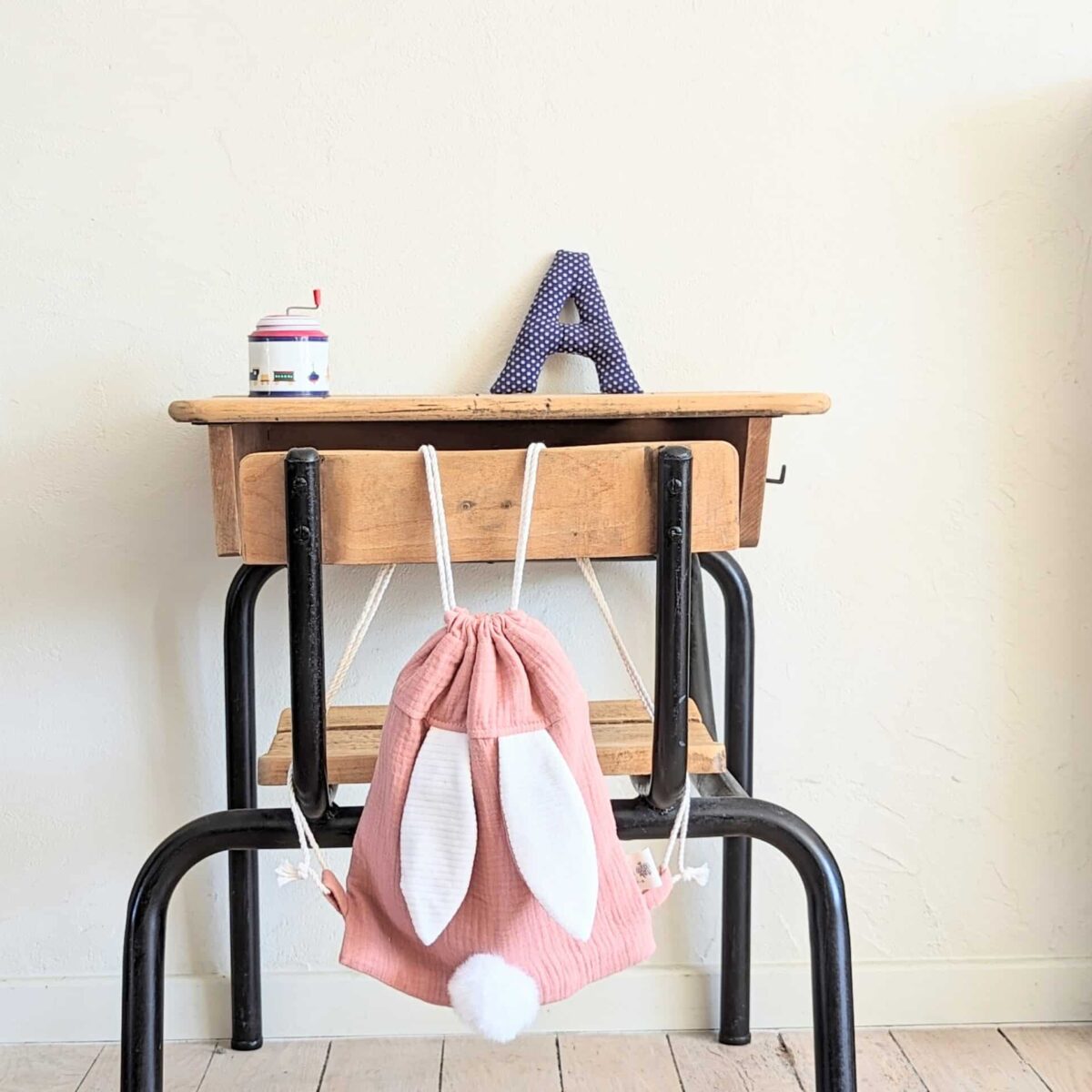 Petit sac pour enfant en double gaze de coton rose avec oreille de lapin et queue de lapin en fourrure blanche.