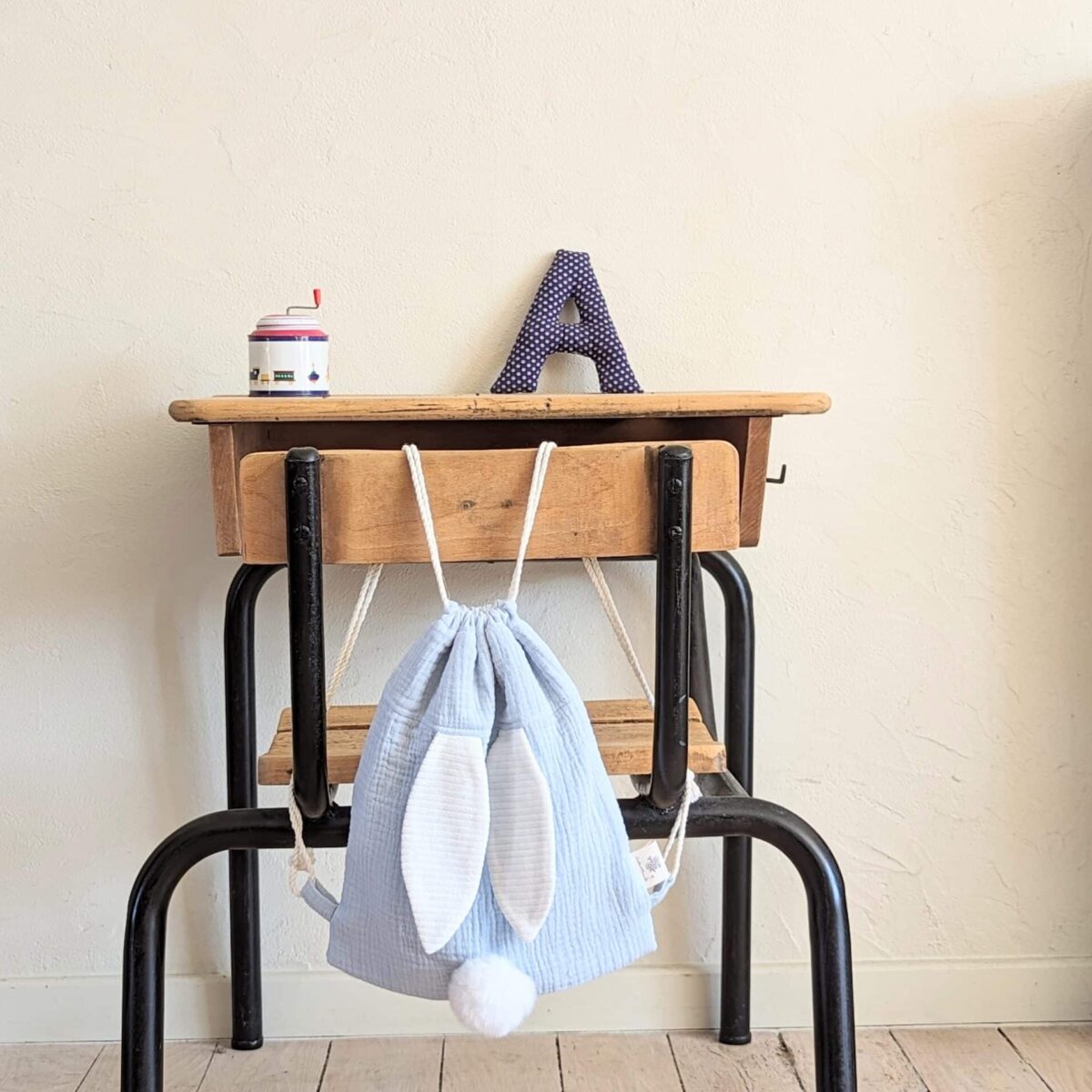 Petit sac pour enfant en double gaze de coton bleu ciel avec oreille de lapin et queue de lapin en fourrure blanche.