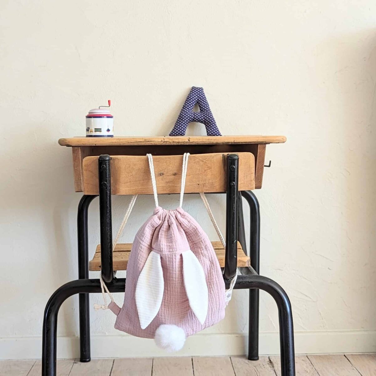 Petit sac pour enfant en double gaze de coton vieux rose avec oreille de lapin et queue de lapin en fourrure blanche.