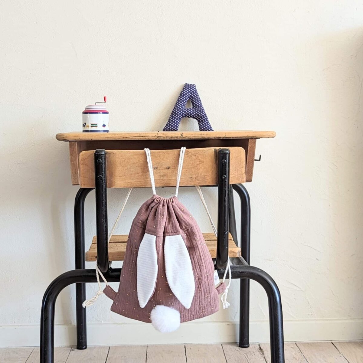 Petit sac pour enfant en double gaze de coton prune avec oreille de lapin et queue de lapin en fourrure blanche.