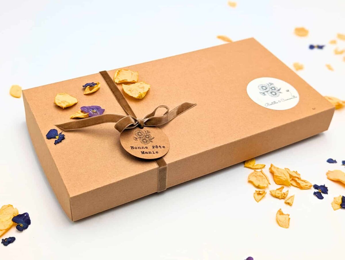 Coffret Mamie Chérie composé d'une petite bougie parfumée à la violette et ornée de fleurs séchées , d'une fiole d'allumettes et d'une éprouvette en fleurs séchées, le tout dans une jolie boîte en kraft