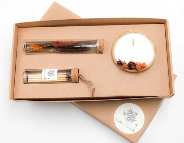 Coffret cadeau avec bougie en fleurs séchées parfumée tonka, fioles d'allumettes et éprouvette de fleurs séchées aux couleurs orange et marron, le tout dans une jolie boîte en kraft.