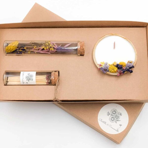 Coffret cadeau avec bougie en fleurs séchées parfumée à la violette, fioles d'allumettes et éprouvette de fleurs séchées aux couleurs violettes, le tout dans une jolie boîte en kraft.