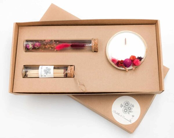 Coffret cadeau avec bougie en fleurs séchées parfumée cerise, fioles d'allumettes et éprouvette de fleurs séchées aux couleurs rouges, le tout dans une jolie boîte en kraft.