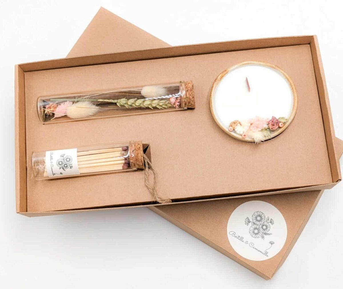 Coffret cadeau avec bougie en fleurs séchées parfumée rose ancienne, fioles d'allumettes et éprouvette de fleurs séchées aux couleurs roses et vertes, le tout dans une jolie boîte en kraft.