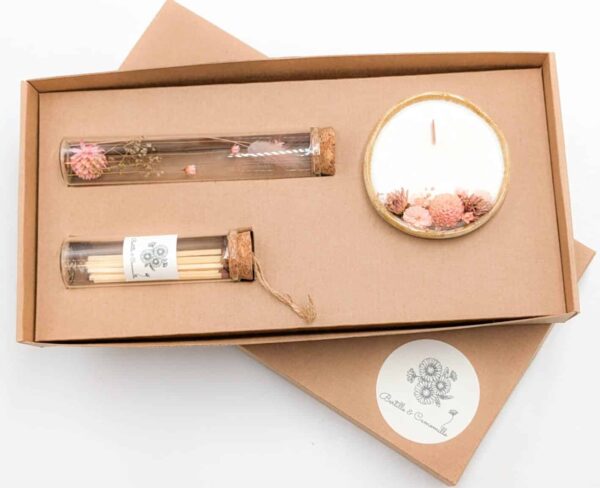 Coffret cadeau avec bougie en fleurs séchées parfumée fleur de tiaré, fioles d'allumettes et éprouvette de fleurs séchées aux couleurs roses, le tout dans une jolie boîte en kraft.