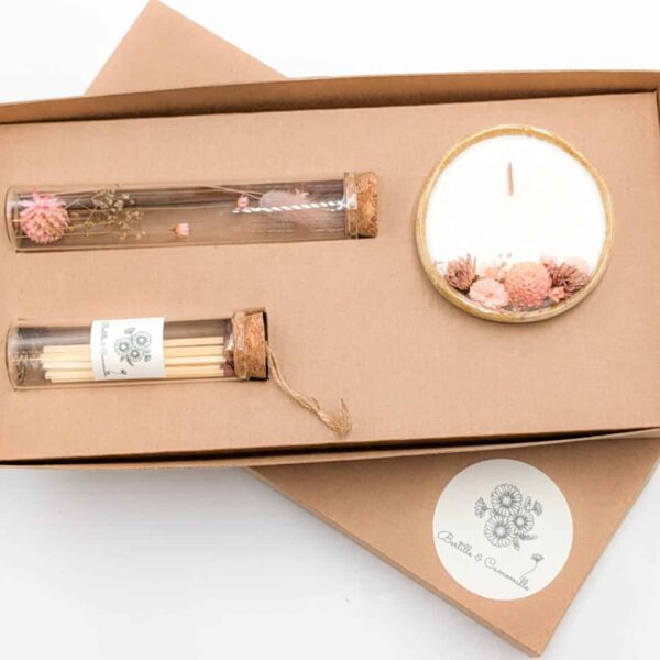 Coffret cadeau avec bougie en fleurs séchées parfumée fleur de tiaré, fioles d'allumettes et éprouvette de fleurs séchées aux couleurs roses, le tout dans une jolie boîte en kraft.