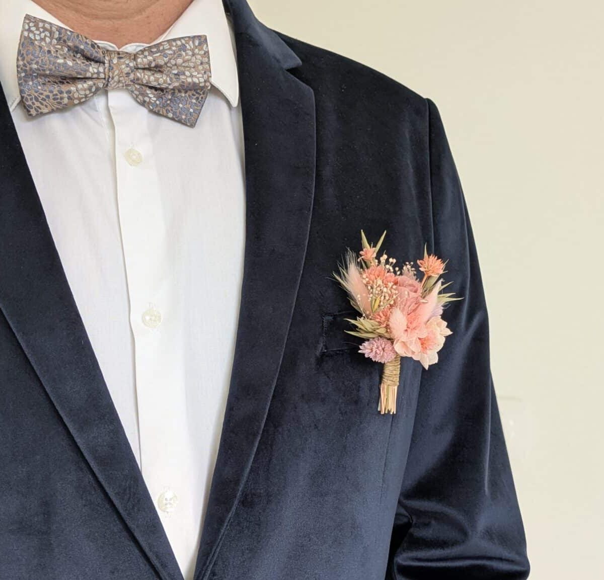 boutonnière mariage en fleurs séchées garçon d'honneur, témoin, marié, enfant de couleur ton rose romantique s'accroche avec son épingle à nourrice